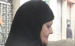 Muslim looking woman looking down near a Bible believing church in the Middle East where presecution often prevents religious freedom.